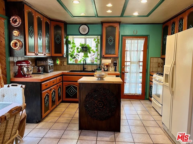 kitchen with white appliances, a center island, decorative backsplash, light tile patterned flooring, and sink