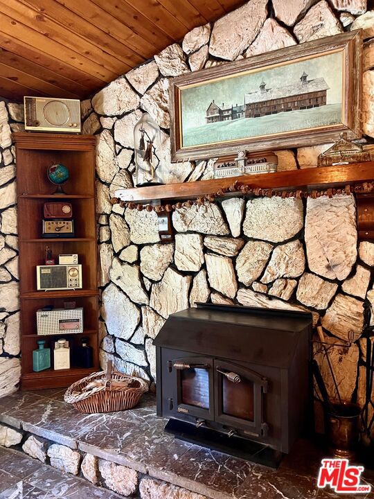 room details with wooden ceiling and a wood stove