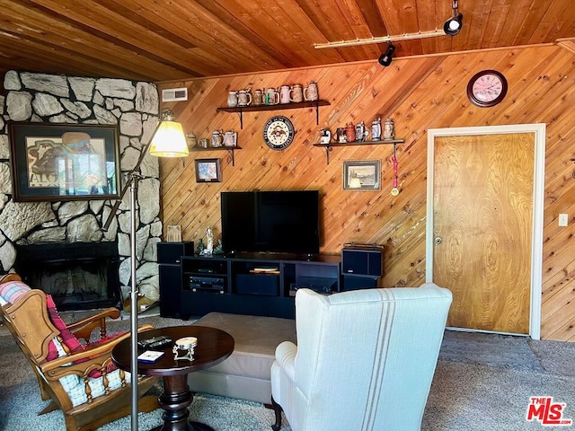 living room with track lighting, wooden ceiling, wood walls, and a fireplace