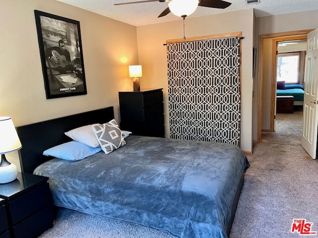 carpeted bedroom with a textured ceiling and ceiling fan