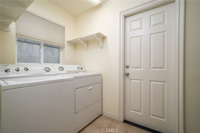 clothes washing area with light tile patterned floors and washer and clothes dryer