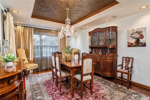 dining area featuring ornamental molding, a tray ceiling, and a chandelier