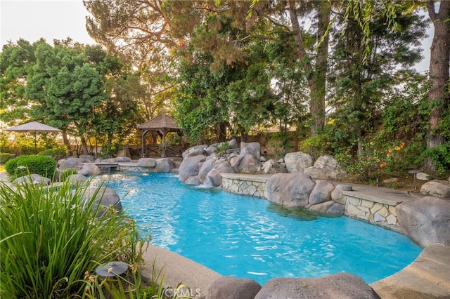 view of swimming pool with a gazebo and pool water feature