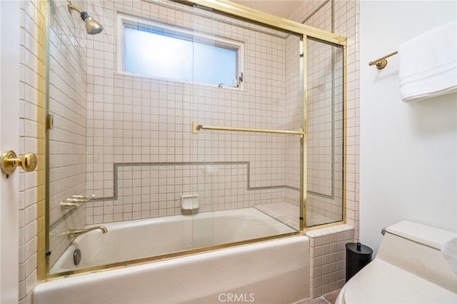 bathroom with shower / bath combination with glass door and toilet