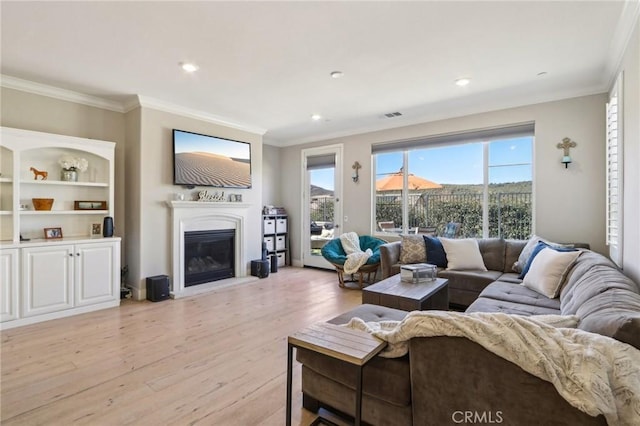 living room featuring crown molding and light hardwood / wood-style flooring