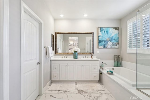 bathroom with a tub to relax in and vanity