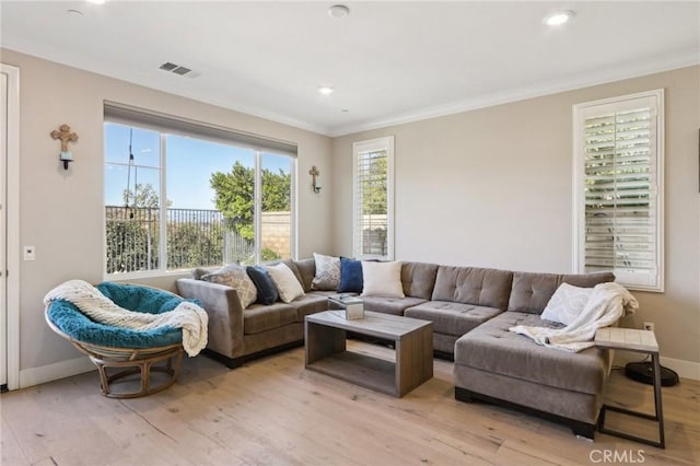 living room with ornamental molding and light hardwood / wood-style floors