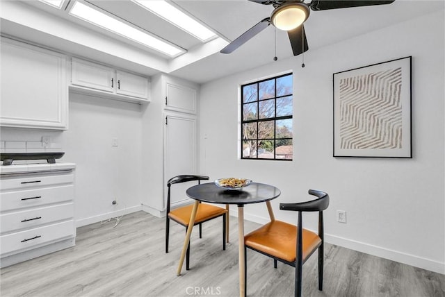 dining space with ceiling fan and light hardwood / wood-style flooring