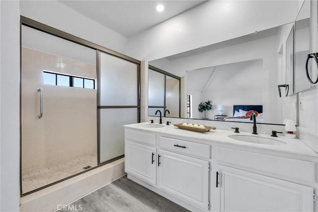 bathroom featuring vanity, hardwood / wood-style floors, and a shower with shower door