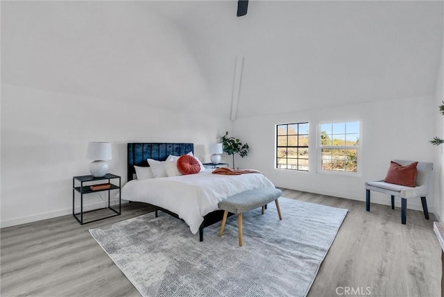 bedroom with ceiling fan, lofted ceiling with beams, and light hardwood / wood-style flooring