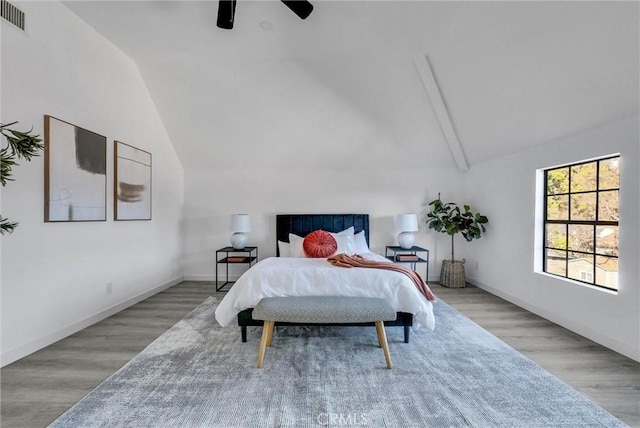 bedroom with ceiling fan, light wood-type flooring, and vaulted ceiling with beams