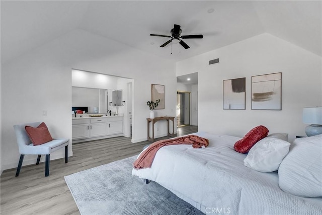 bedroom with lofted ceiling, ceiling fan, light hardwood / wood-style flooring, and connected bathroom