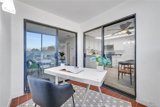 tiled office space featuring ceiling fan