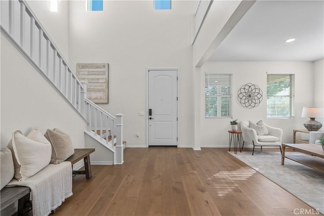 entryway with a towering ceiling and hardwood / wood-style floors