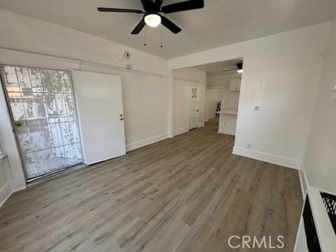 unfurnished living room featuring wood-type flooring and ceiling fan