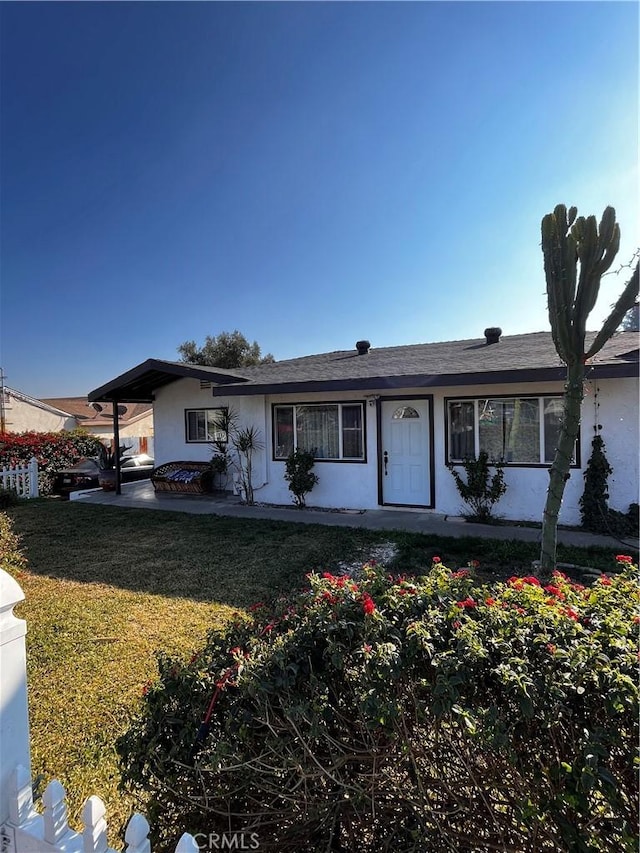 single story home featuring a front yard and a patio