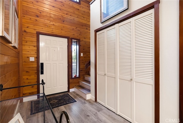 entrance foyer with wooden walls and light hardwood / wood-style floors