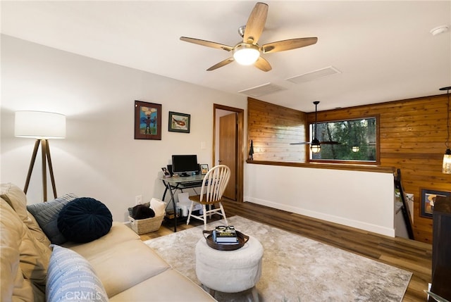 living room with hardwood / wood-style flooring and wood walls