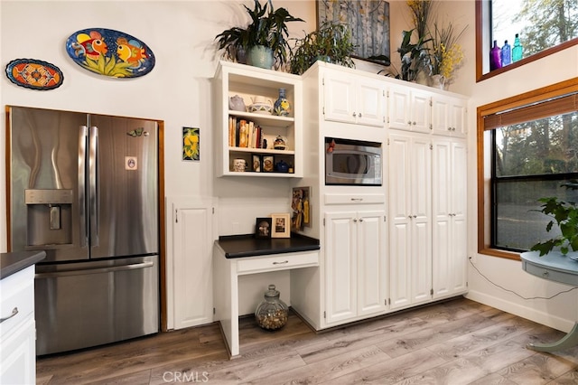 kitchen featuring white cabinetry, light hardwood / wood-style floors, and appliances with stainless steel finishes