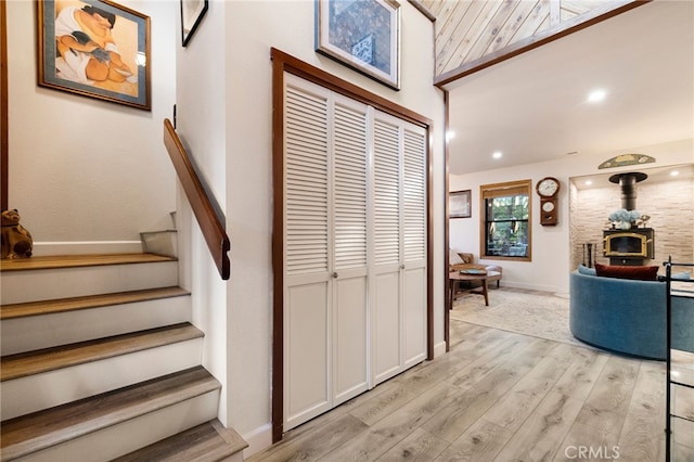 stairway featuring wood-type flooring and a wood stove