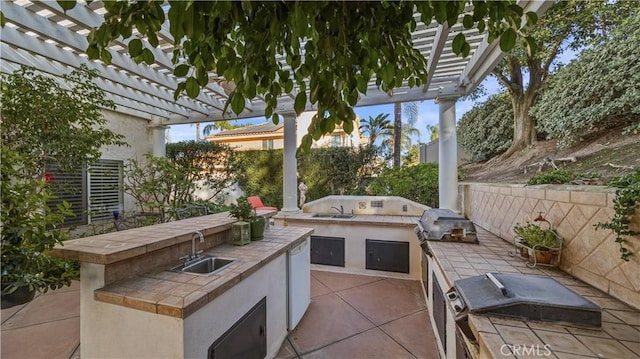 view of patio featuring an outdoor kitchen, sink, a pergola, and area for grilling