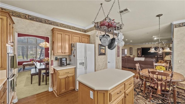 kitchen featuring white fridge with ice dispenser, a center island, ornamental molding, stainless steel double oven, and light hardwood / wood-style flooring