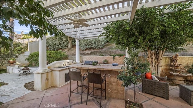 view of patio featuring an outdoor fire pit, a pergola, an outdoor bar, and exterior kitchen