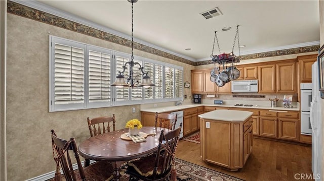 kitchen with white appliances, a center island, decorative light fixtures, an inviting chandelier, and dark hardwood / wood-style flooring