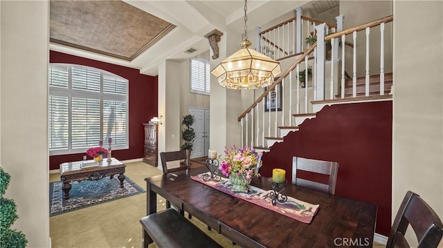 dining room featuring carpet floors, a chandelier, and ornamental molding