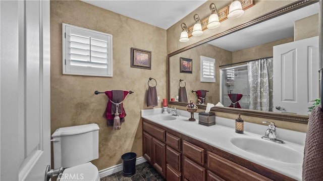 bathroom with curtained shower, vanity, and toilet