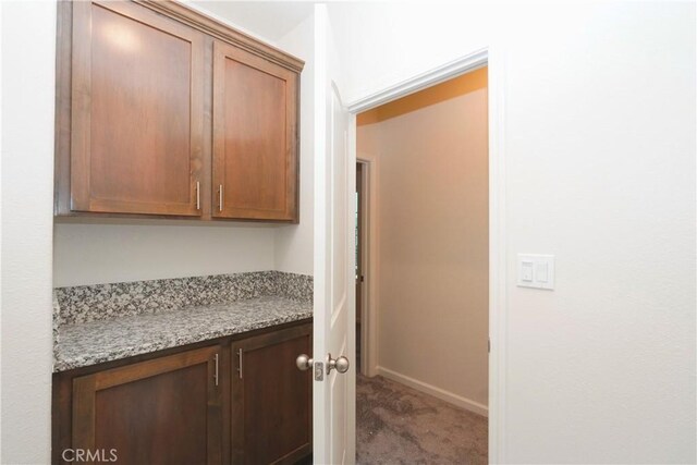 interior space with stone countertops and dark carpet