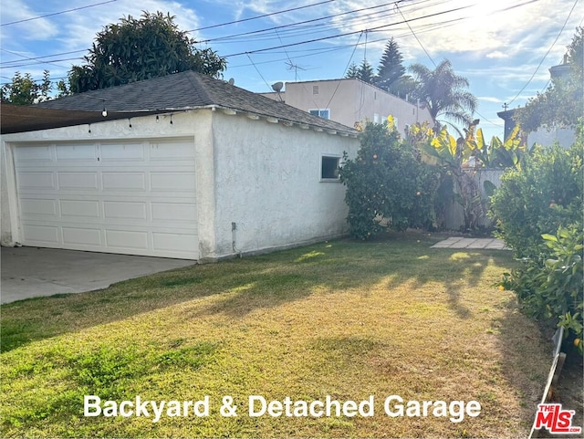 exterior space with a yard, a garage, and an outdoor structure