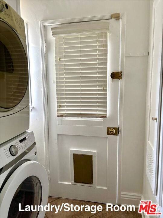 clothes washing area featuring stacked washer / dryer