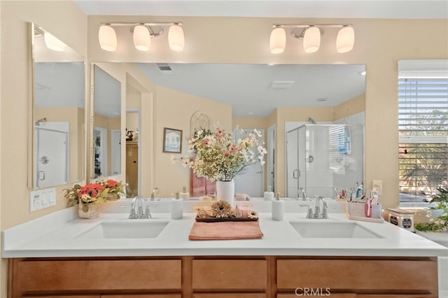 bathroom with a shower with shower door and vanity