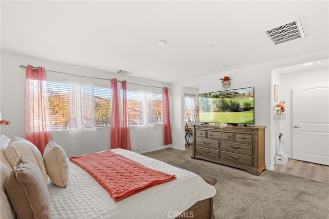 bedroom featuring light colored carpet and multiple windows