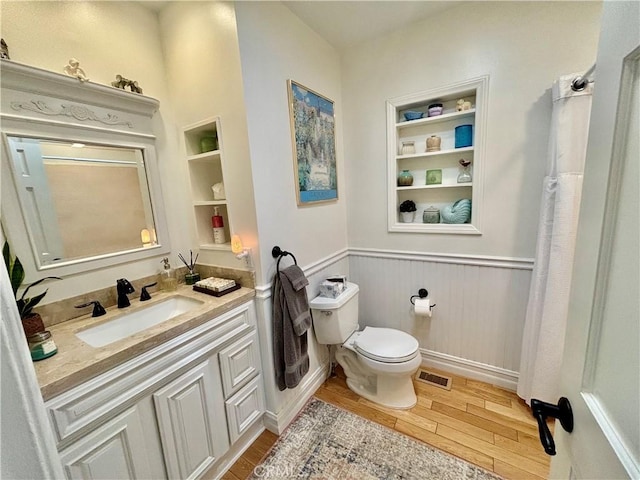 bathroom with built in features, vanity, and toilet