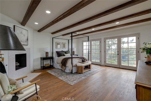 bedroom featuring french doors, access to exterior, beamed ceiling, and wood-type flooring