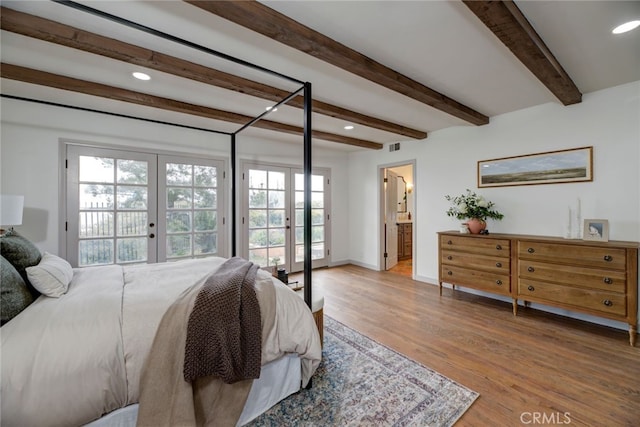 bedroom with access to outside, connected bathroom, beamed ceiling, and wood-type flooring