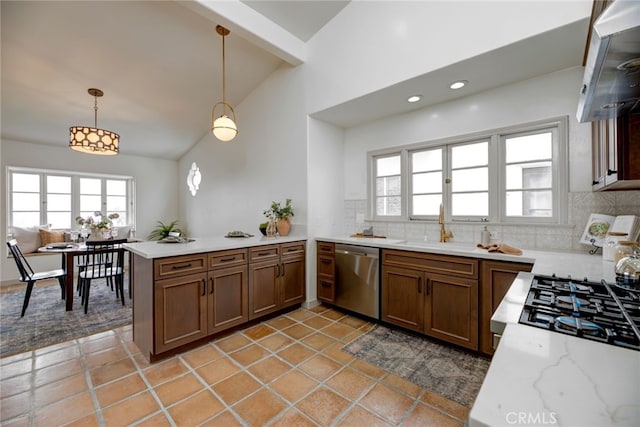 kitchen with kitchen peninsula, dishwasher, decorative light fixtures, decorative backsplash, and lofted ceiling