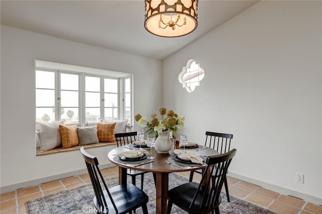 dining area with tile patterned flooring and vaulted ceiling