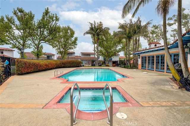 view of pool with a patio area and an in ground hot tub