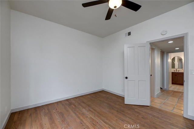 empty room featuring sink, ceiling fan, and hardwood / wood-style flooring