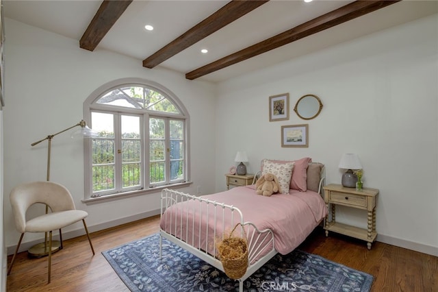 bedroom with hardwood / wood-style floors and beam ceiling