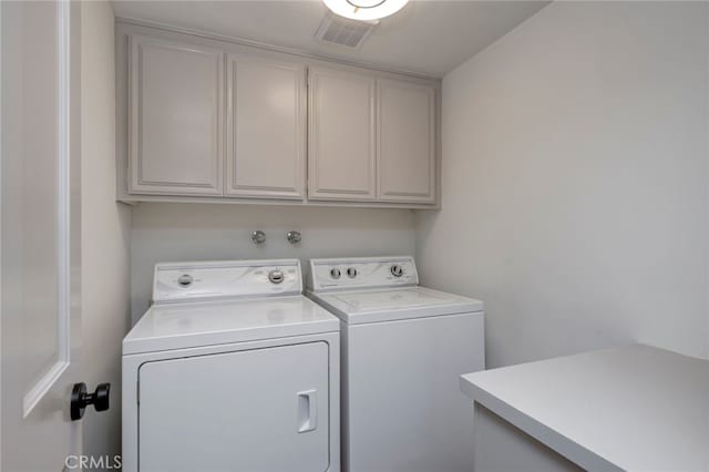 washroom featuring separate washer and dryer and cabinets