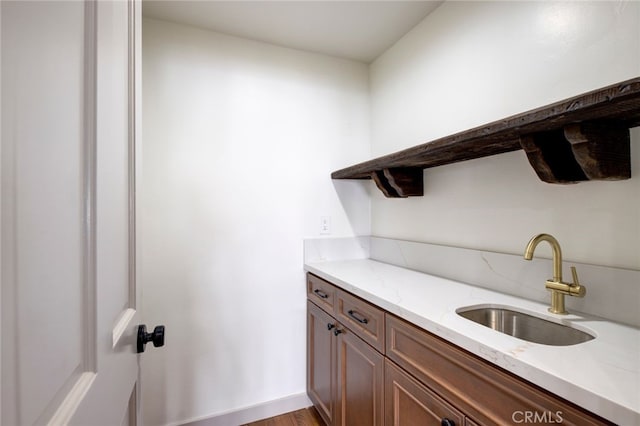 interior space featuring sink, light wood-type flooring, and light stone counters