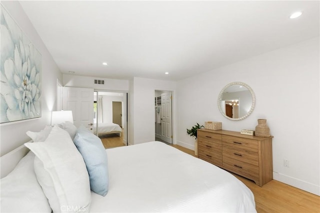 bedroom featuring a spacious closet, hardwood / wood-style floors, and a closet