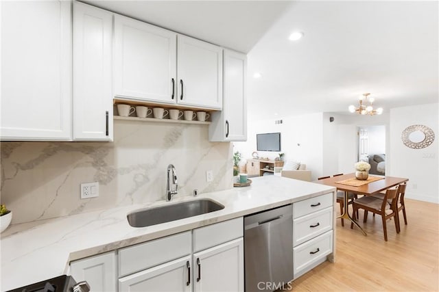 kitchen with backsplash, dishwasher, sink, and white cabinets