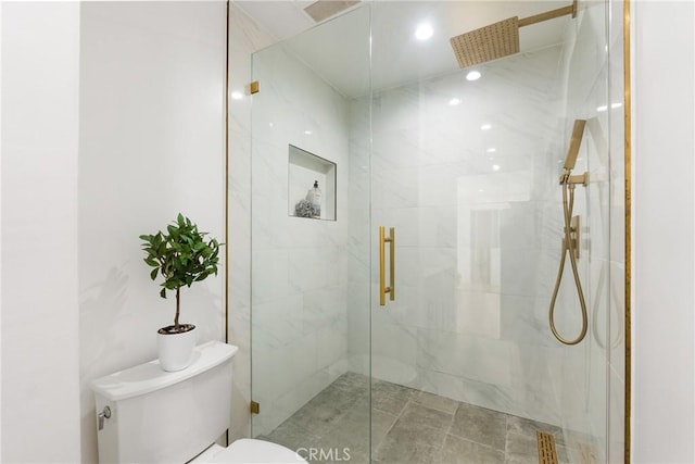 bathroom with toilet and a shower with shower door