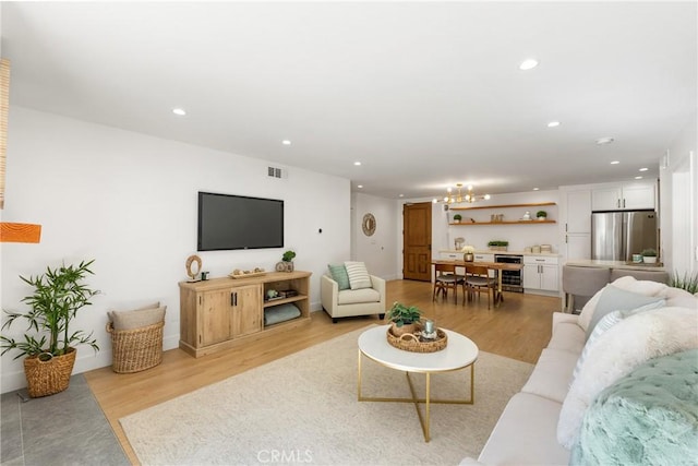 living room with light hardwood / wood-style flooring and a chandelier