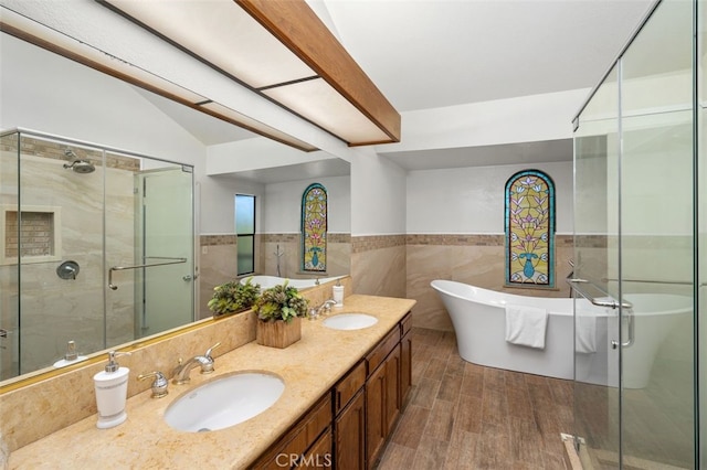 bathroom featuring shower with separate bathtub, vaulted ceiling, wood-type flooring, tile walls, and vanity